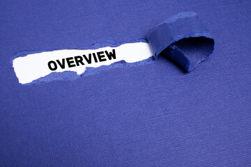 The text OVERVIEW appearing on whitepaper behind torn blue paper.