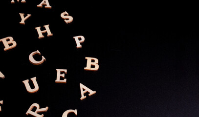 random wooden letters isolated on black background