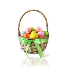 Easter wicker basket with pastel colorful eggs decorated with green satin bow isolated on white background. Festive Christianity religion tradition.