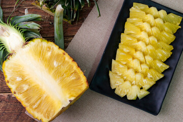 Top view Pineapple slices and pineapple shelled Asian-style on the wooden background.