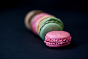 The Netherlands. January 2022. Close up of colorful macarons against a black background.