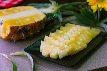 Pineapple slices and pineapple shelled Asian-style on the wooden background.