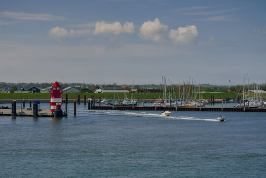 Speed boats on the sea, getting out from the port Wyk auf F&ouml;hr.  Motorboats leaving marina Wyk auf F&ouml;hr. Coastal landscape with marina at Wyk auf F&ouml;hr. Red pier light in harbour of Wyk auf F&ouml;hr. 