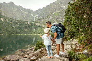 Photo sur Plexiglas Tatras Man and child tourists in mountains at Morskie Oko lake near Zakopane, Tatra Mountains, Poland. Family travel concept.