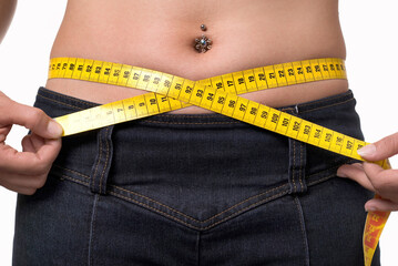Young woman with a measuring tape as a symbol for body cult, diet and fitness