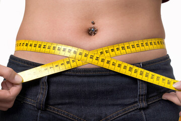 Young woman with a measuring tape as a symbol for body cult, diet and fitness