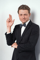 Looking out of orange notebook or journal young man in eye glasses wearing white shirt isolated on white background or in the office. Portrait of a shy young businessman holding his diary. 