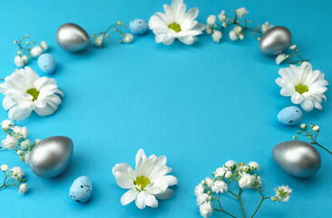 Fototapeta na wymiar Easter background of flowers and eggs on a blue background. Bright space for your text