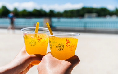 Make or raise a toast with fresh orange juice on a sunny day. Holiday cheers with tropical juice or healthy drink on a hot day. Spanish vacation, couple relaxation, celebration and enjoyment concept