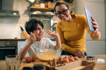 mother and her son baking together in kitchen. having video chat