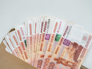 Money in envelope on white background. Cash in envelope. Russian roubles. RUB. Russian money in envelope. Savings. Bribery and corruption. Bribe in envelope. Russian money. Money laundering