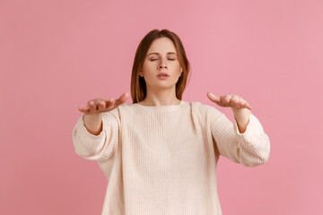 Portrait of blind blond young woman walking with closed eyes, reaching out hands to find lost way,...