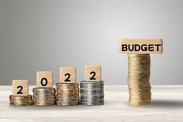 Wooden blocks concept with coins in vintage background.