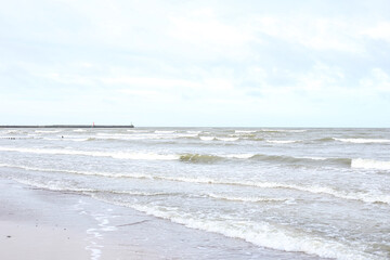 Baltic landscape view with baltic sea with concrete sea port in background.