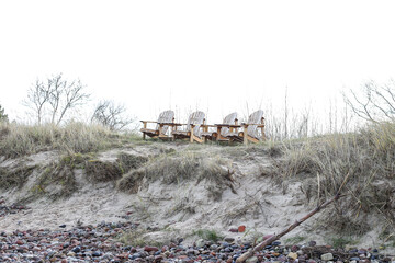 Four wood seats near sand shore and Baltic beach.