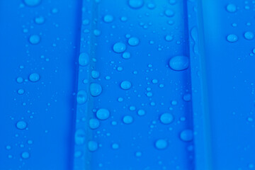 Naklejka na ściany i meble Water droplets scattered on blue background.