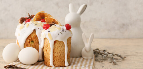 Delicious Easter cakes with eggs, bunny figurines and pussy willow branches on grunge background with space for text