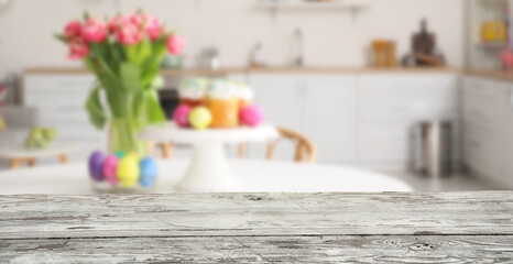Empty wooden table in kitchen decorated for Easter celebration