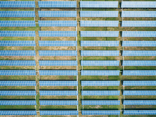 Aerial top down shot of solar panels farm on the green field. Renewable alternative green energy concept. © Evgenii Bakhchev