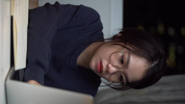 a cute Vietnamese girl is working on her computer and showing her cute facial expression and cute movement and staring at the camera