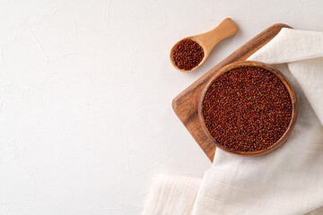 Organic red quinoa in a bowl on white table background.