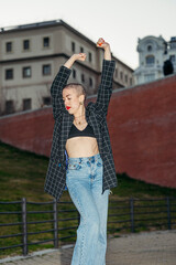 Fototapeta premium Young bald woman dancing in the street.