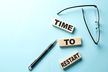 TIME TO RESTART text on the wooden block ,blue background