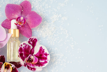 cosmetic oil with orchid flowers, spa, space for text, flat view, self care concept 