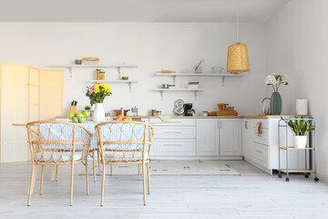 Interior of modern kitchen with dining table and beautiful Chrysanthemum flowers
