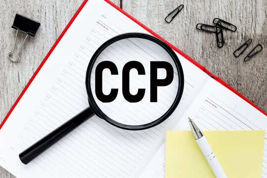 Business Acronym CCP Critical Control Point. text on a magnifying glass and an open red notepad. business concept