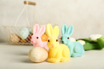 Beautiful Easter bunnies and painted egg on light background
