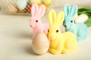 Beautiful Easter bunnies and painted egg on light background