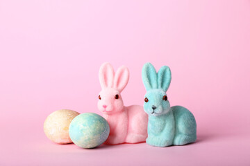 Beautiful Easter bunnies and painted eggs on pink background