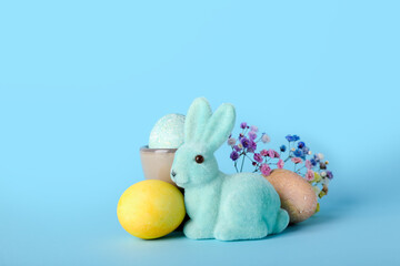 Beautiful Easter bunny and painted eggs on blue background