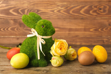 Beautiful Easter bunny, flowers and painted eggs on wooden background