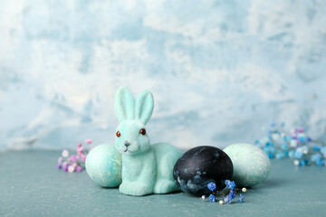 Beautiful Easter bunny and painted eggs on blue background