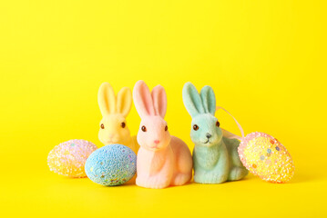 Beautiful Easter bunnies and painted eggs on yellow background