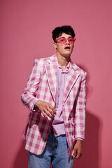 portrait of a young man self confidence pink plaid blazer fashion posing pink background unaltered