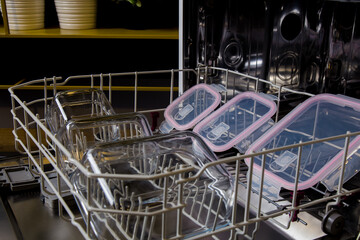 Obraz premium storage containers visible inside the dishwasher in the kitchen are ready to be washed