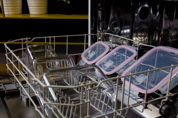 storage containers visible inside the dishwasher in the kitchen are ready to be washed