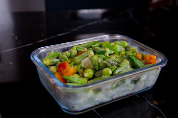frozen vegetables in storage container on granite countertop
