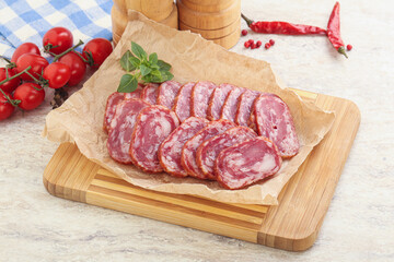 Sliced salami sausages over board