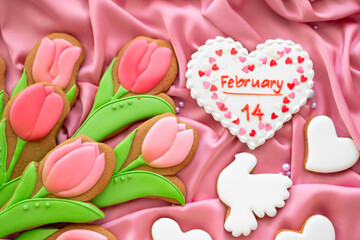 background banner greeting card for 14 february Valentines day with white and pink heart, tulips and pigeon shape gingerbread cookies on pink silk fabric background