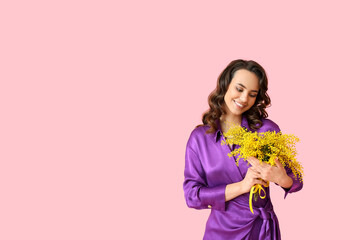 Smiling young woman with mimosa flowers on pink background. International Women's Day - obrazy, fototapety, plakaty