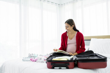 healthy pregnant woman I'm packing a bag of clothes for my baby. to prepare for childbirth