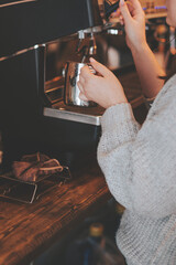 The barista cooks cappuccino in a coffee machine. The process of making coffee in a coffee shop