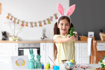 Funny little girl with toy bunny and Easter eggs at home