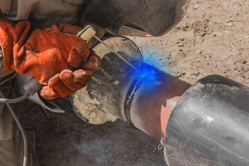 A welder is engaged in welding work on the polyethylene pipe of the heating main pipeline at the...
