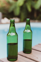 Two green bottles of beer by the pool. Summer Party
