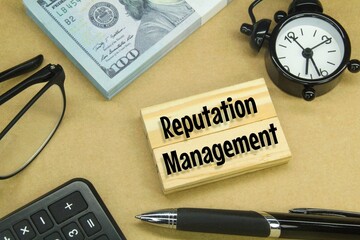 glasses, banknotes, pens, alarm clocks and wooden boards with the word reputation management